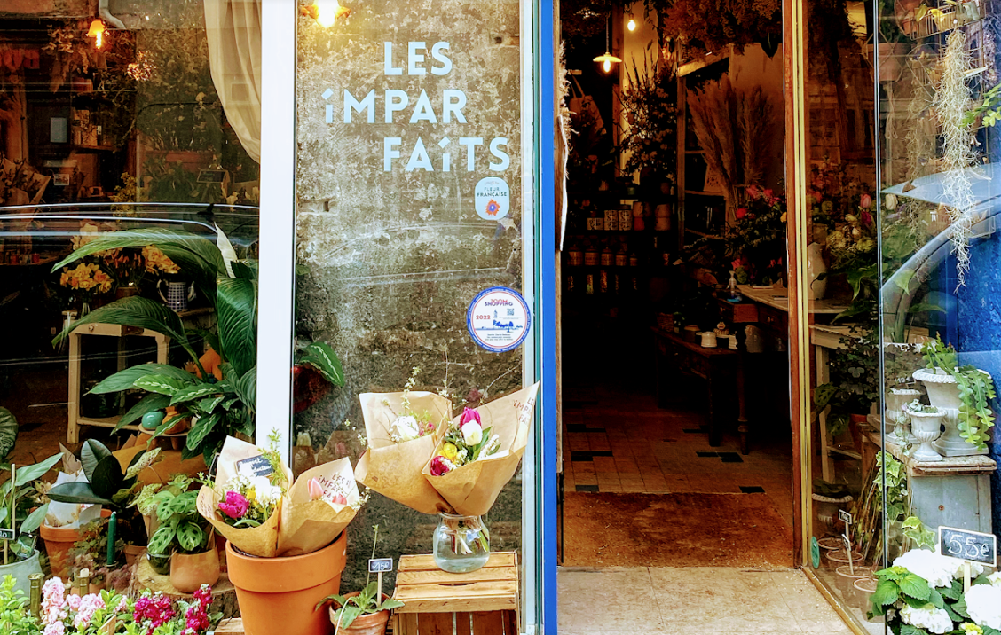 Une image contenant magasin, pot de fleurs, plante d’intérieur, bâtimentDescription générée automatiquement
